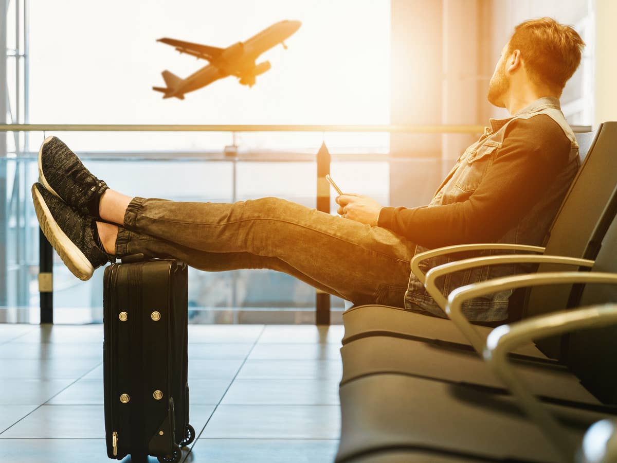 Mann im Flughafen mit einem Koffer