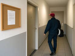 Ein Techniker läuft einen Hausflur entlang