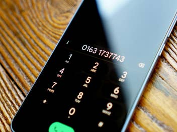 Auf dem Smartphone-Display ist eine Telefonnummer