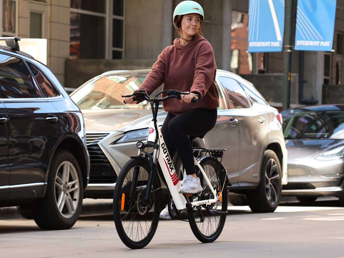 Eine junge Frau fährt mit dem Fahrrad durch die Stadt.