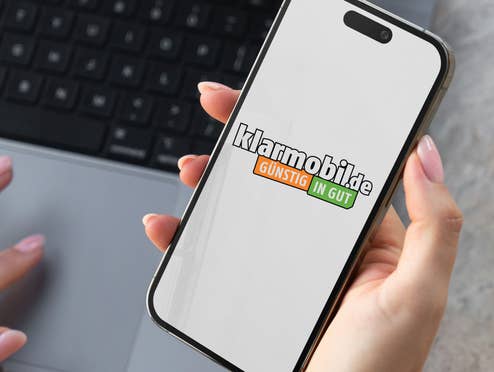 Frau hält Smartphone auf dem das klarmobil-Logo zu sehen ist