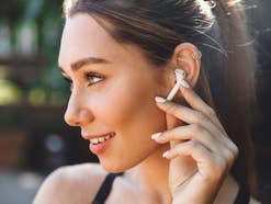 Eine Frau hört Musik mit AirPods-Kopfhörern von Apple