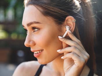Eine Frau hört Musik mit AirPods-Kopfhörern von Apple
