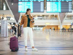 Frau mit Koffer am Flughafen