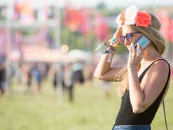 Frau mit Smartphone auf Glastonbury Festival.