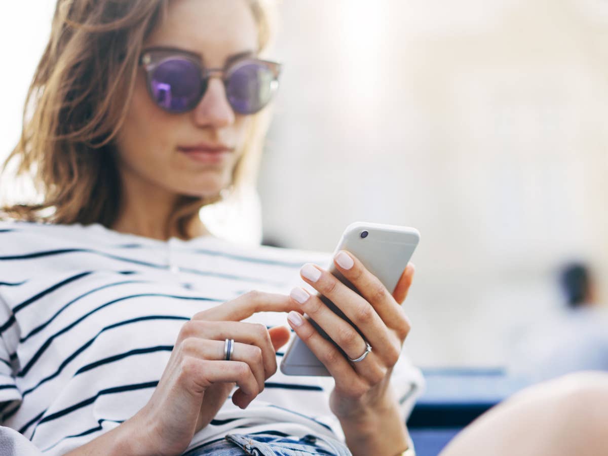 Handytarif für 8 Euro Frau mit Sonnenbrille schaut auf ihr Smartphone