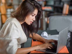 Frau schaut gestresst auf einen Laptop