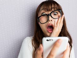 Frau blickt geschockt auf ihr Smartphone