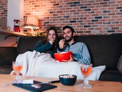 Ein Pärchen sitzt auf der Couch und schaut einen Film