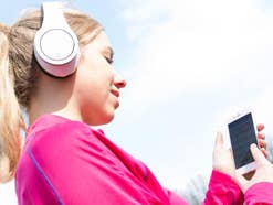 Eine Frau hört Radio mit Smartphone und Kopfhörer