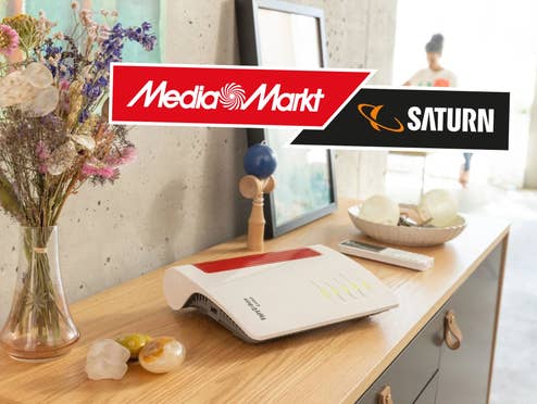 FritzBox Router 6670 Cable auf einem Tisch, daneben das Logo von MediaMarkt