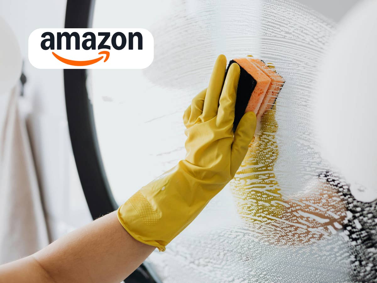 fruehjahrsputz-gadgets-die-jeder-braucht-amazon Jemand, der einen Spiegel putzt, mit gelbem Handschuh an und einem Schwamm in der Hand. Darauf das Amazon-Logo.