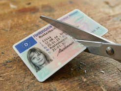 Ein Führerschein wird mit einer Schere zerschnitten