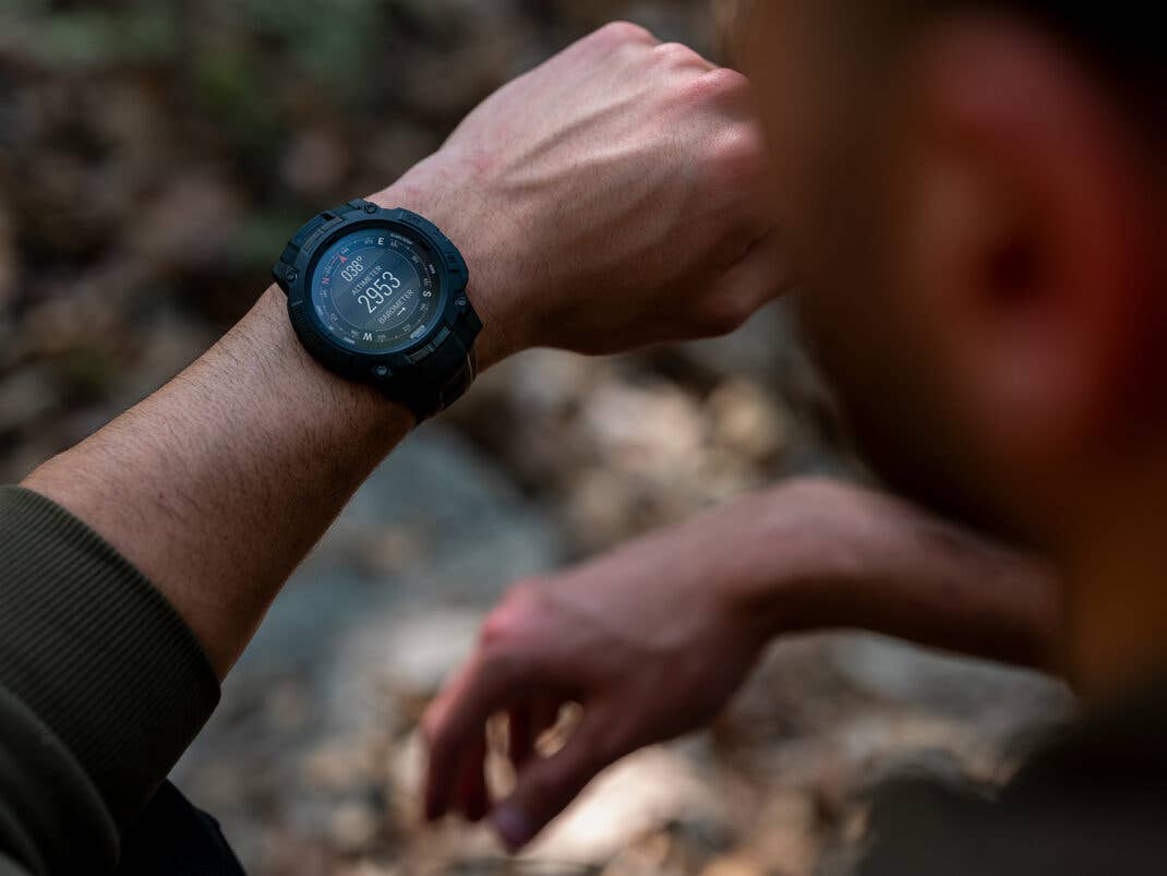 Nahaufnahme einer Garmin Instinct 3 Tactical Edition-Uhr am Handgelenk, die ein digitales Display mit der Anzeige 2933 zeigt.