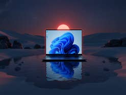 Geekom-Laptop in einer Wüste bei Nacht. Sein Spiegelbild erscheint in einer Oase.