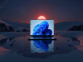 Geekom-Laptop in einer Wüste bei Nacht. Sein Spiegelbild erscheint in einer Oase.