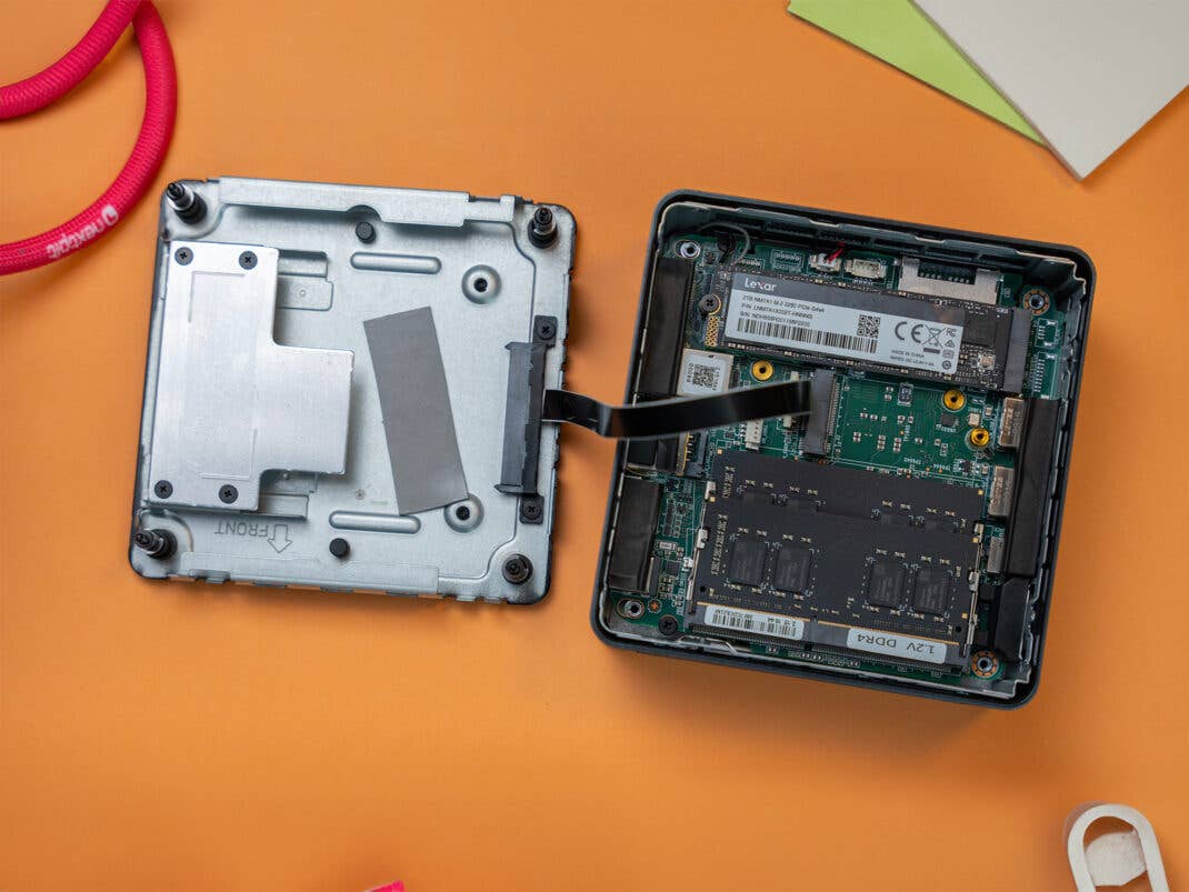 Geekom Mini IT13 ist aufgeschraubt und die Hauptplatine sowie die Adeckung sind auf einem Schreibtisch ausgebreitet.