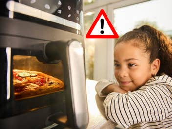 Kind schaut auf eine Heißluftfritteuse, daneben ein warnendes Dreieck mit Ausrufezeichen