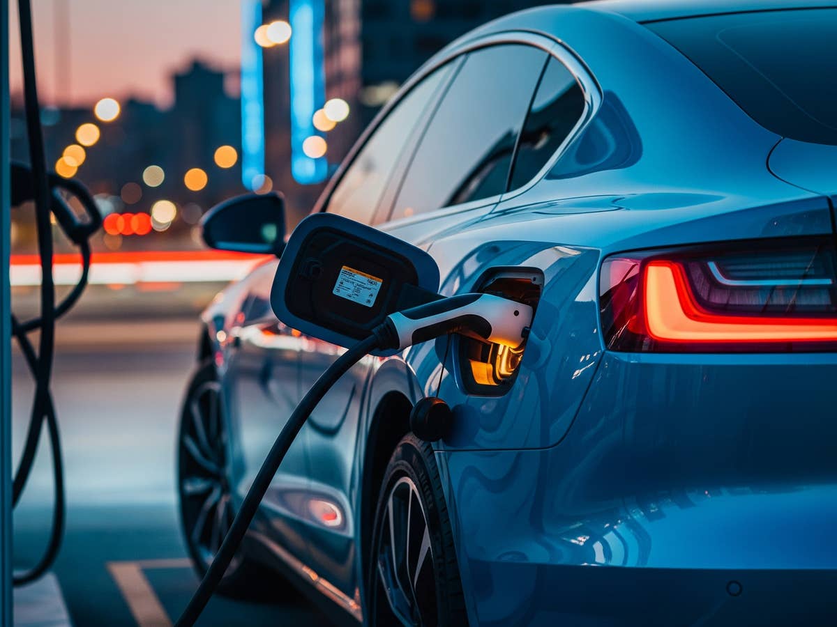 E-Auto an einer städtischen Ladesäule bei Dämmerung.