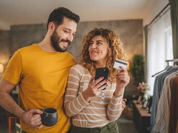 Glückliches Paar kauft etwas via Smartphone