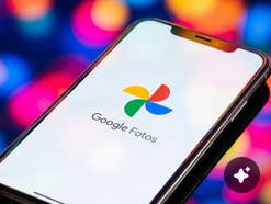 Smartphone mit Google Photos Logo vor bunten Hintergrund.
