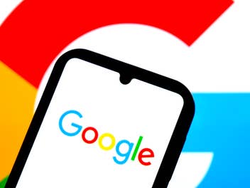 Google-Logo auf einem Smartphone mit einem Google-G im Hintergrund.