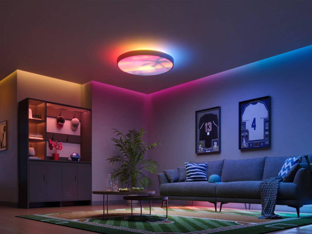 Die neue Govee Ceiling Light Ultra stellt eine Strandlandschaft abstrakt in einem dunklen Wohnzimmer dar.