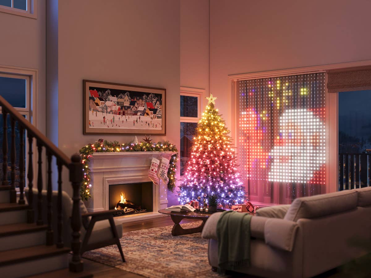 Ein weihnachtliches Wohnzimmer wird durch smarte Lichter beleuchtet. Weihnachtsbaum und Vorhänge leuchten Bund und in Motiven.
