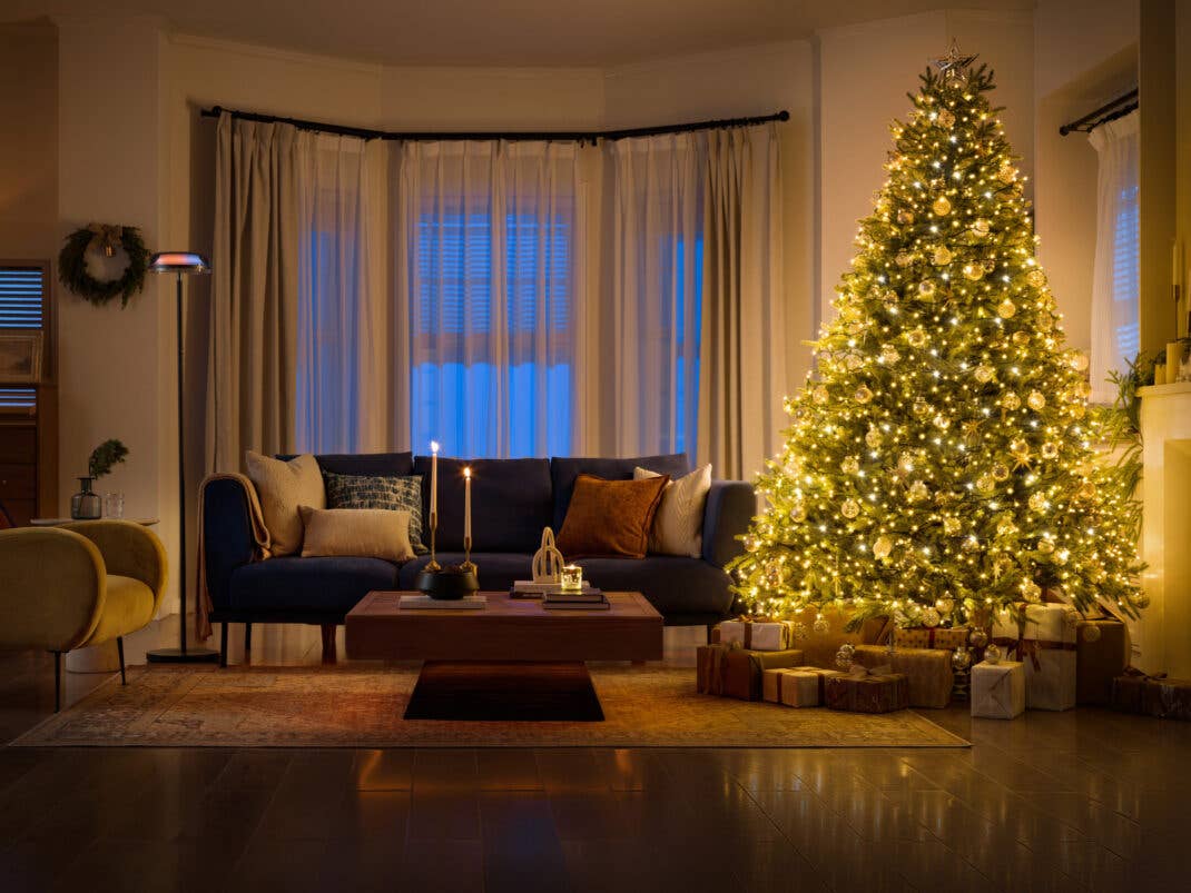 Ein dunkles weihnachtliches Wohnzimmer wird durch smarte Lichter beleuchtet.