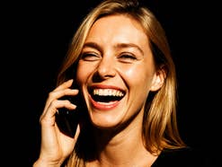 Frau lacht und telefoniert.