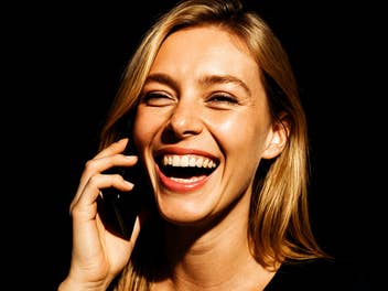 Frau lacht und telefoniert.