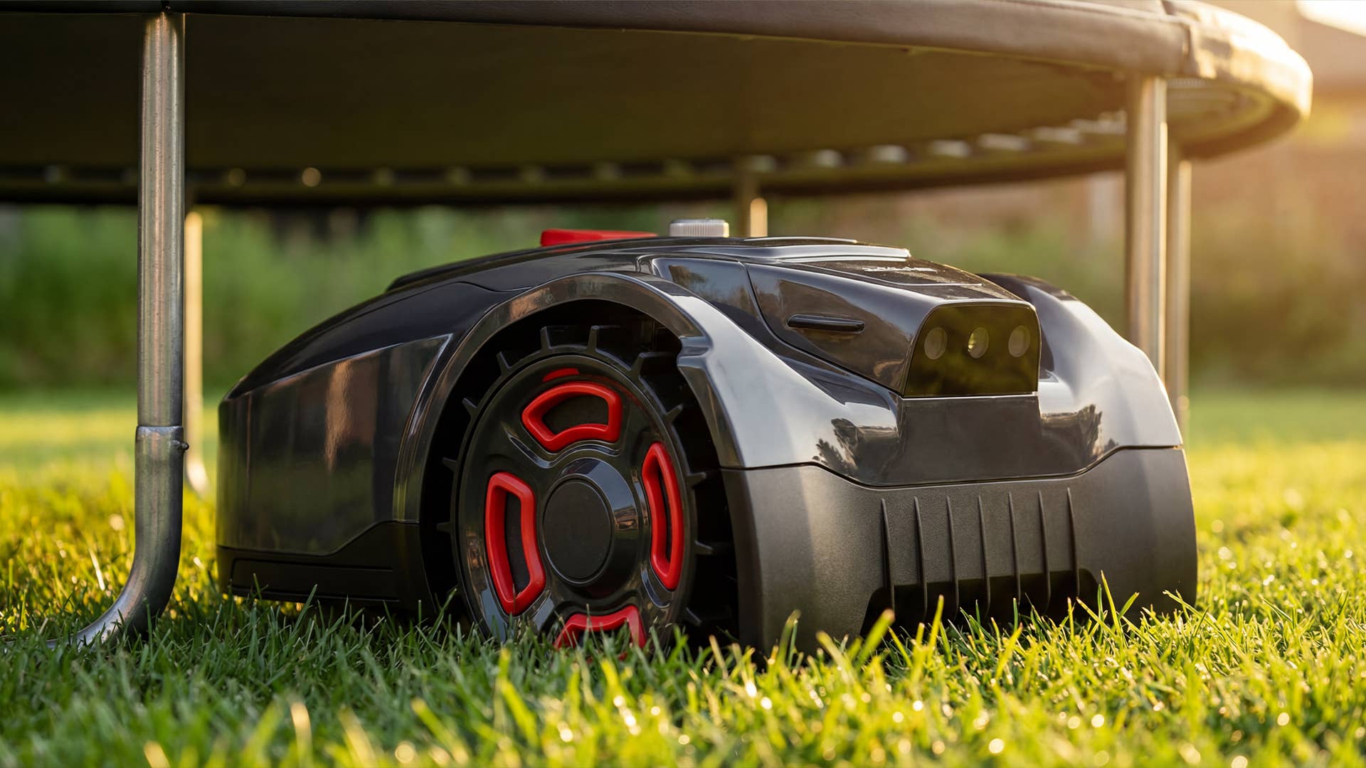 Mähroboter fährt unter einem Trampolin hindurch