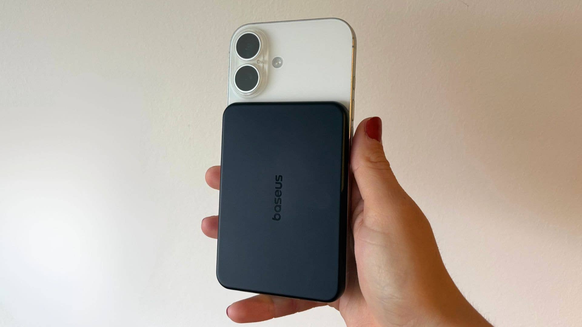Eine Hand hält ein iPhone mit der Baseus PicoGo Air AM71 Powerbank