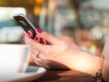 Eine Frau hält ein Mobiltelefon in der Hand