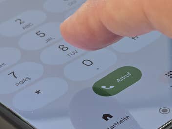 Ein Finger tippt auf der Telefontastatur eines Handys
