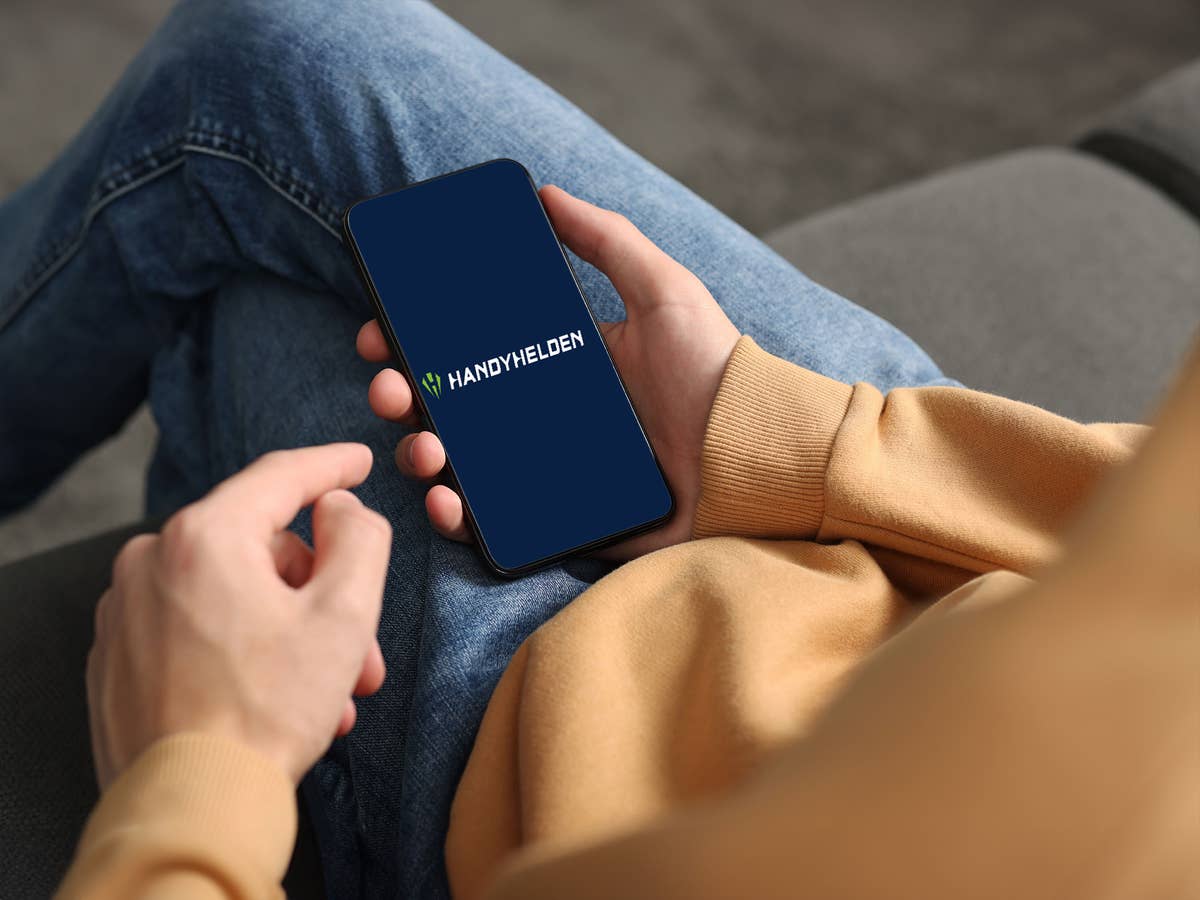 handyhelden-logo-auf-smartphone Eine Person hält ein Smartphone auf dem das Handyhelden-Logo zu sehen ist.