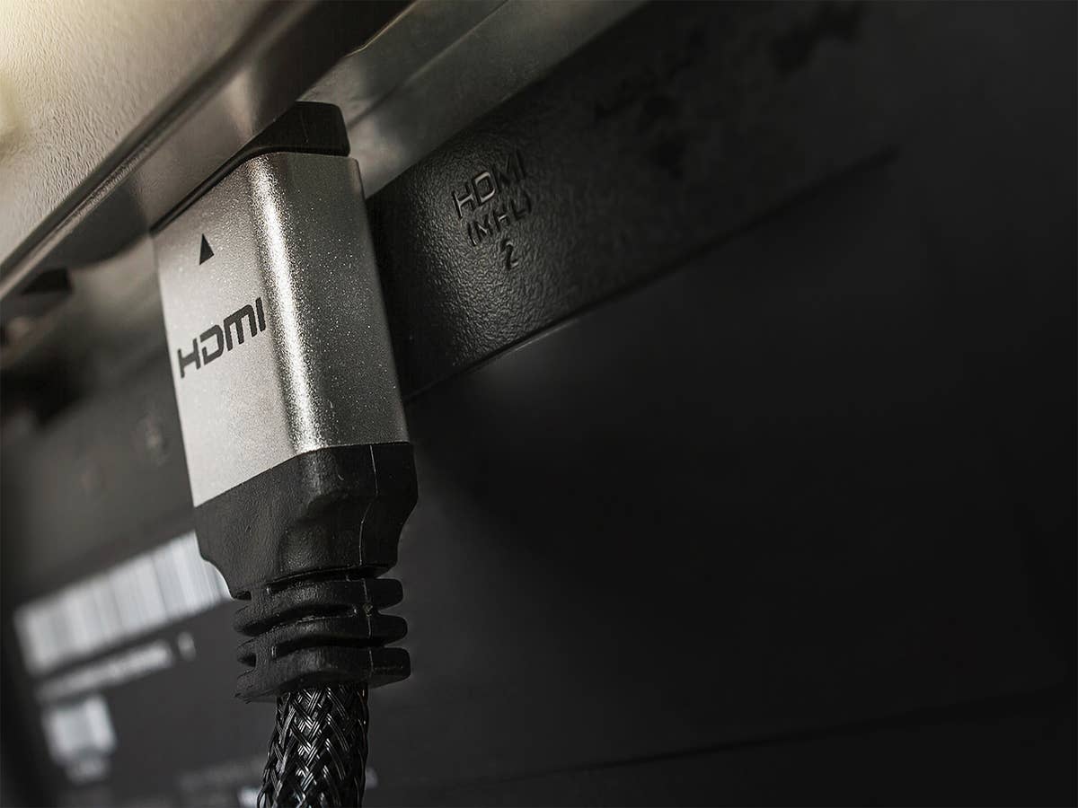 SIlbernes HDMI-Kabel an einem Fernseher.