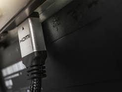 SIlbernes HDMI-Kabel an einem Fernseher.