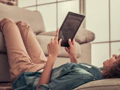 Frau surft zuhause mit dem Tablet
