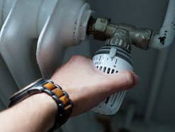 Thermostat an einer Heizung wird gedreht