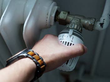 Thermostat an einer Heizung wird gedreht