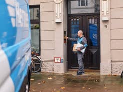Ein Paketzusteller von Hermes vor einer Haustür