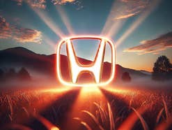 Honda zeigt ungewohnt futuristische E-Autos Glühendes Logo von Honda vor einem Sonnenaufgang.