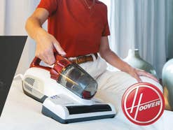 Hoover Ultra Vortex wird von einer Person bedient. Das Hoover-Logo ist auf dem Bild zu sehen.