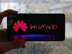 Huawei Logo auf dem Mate 10 Pro in der Hand vor verregneter Scheibe