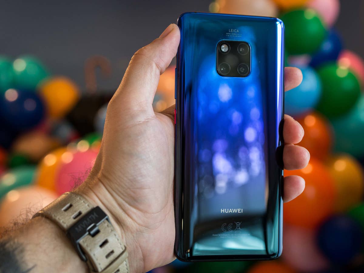 Huawei Mate 20 Pro in der Farbe Twilight in der Hand vor einem Stapel bunter Luftballons