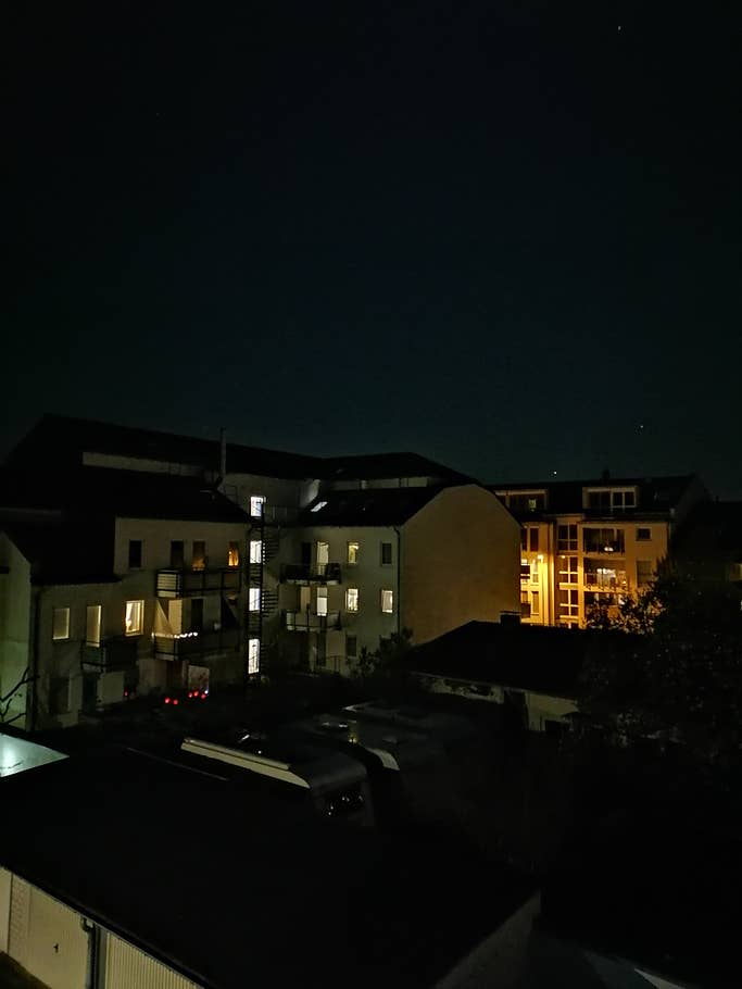 Erleuchtete Fenster in einem Wohngebiet bei Nacht.