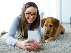 Frau mit Hund und Smartphone