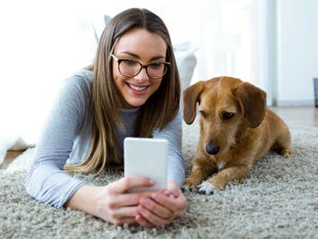 Frau mit Hund und Smartphone