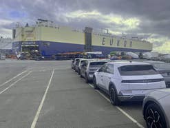 Mehrere IONIQ 5 stehen im Hafen von Bremerhaven vor einem Autofrachter.